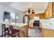 Well-lit kitchen with stainless steel appliances, wood cabinets, breakfast bar, and ample counter space at 8613 Santa Fe Dr, Thornton, CO 80260
