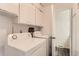 Functional laundry room with white cabinets, washer, and dryer units at 8613 Santa Fe Dr, Thornton, CO 80260