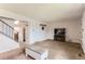 Spacious carpeted living room with neutral walls, staircase access, and cozy fireplace at 8613 Santa Fe Dr, Thornton, CO 80260