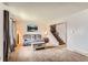 Cozy carpeted living room with neutral walls, comfortable seating, and staircase access to upper level at 8613 Santa Fe Dr, Thornton, CO 80260