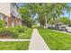 Landscaped street view featuring a sidewalk, well-manicured lawn, mature trees, and neighborhood residences at 8613 Santa Fe Dr, Thornton, CO 80260