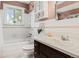 Bathroom with a shower-tub combo, white tile, and a dark wood vanity with a white countertop at 5920 Garrison St, Arvada, CO 80004