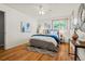 Bright bedroom showcasing hardwood floors, a ceiling fan, and a comfortable bed with stylish decor at 5920 Garrison St, Arvada, CO 80004
