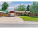 Charming single-story home with a brick facade, well-manicured lawn, and a paved driveway at 5920 Garrison St, Arvada, CO 80004