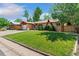 Charming single-story home with a well-maintained lawn and mature trees, showcasing its inviting curb appeal at 5920 Garrison St, Arvada, CO 80004