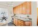 Kitchen with extensive wooden cabinets, granite countertops, and a cozy dining area visible through the doorway at 5920 Garrison St, Arvada, CO 80004