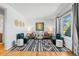 Bright living room featuring a modern rug, stylish seating, and large window, creating a welcoming space at 5920 Garrison St, Arvada, CO 80004