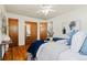 Bedroom with hardwood floors, a ceiling fan, and a neatly made bed with blue and white accents at 5920 Garrison St, Arvada, CO 80004