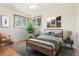 Cozy bedroom with hardwood floors, large windows, and a comfortable bed with a decorative gray rug and stylish wall art at 5920 Garrison St, Arvada, CO 80004