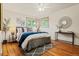 Bedroom boasting hardwood floors, ample natural light from two windows, and stylish decor including a gray rug at 5920 Garrison St, Arvada, CO 80004