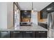 Beautiful kitchen showcasing granite counters, dark cabinets, brick accent wall, and modern pendant lighting at 2566 N Emerson St, Denver, CO 80205