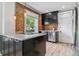 Charming kitchen featuring granite counters, dark cabinets, brick accent wall, and stainless steel appliances at 2566 N Emerson St, Denver, CO 80205
