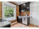 Bright kitchen with stainless steel appliances, granite counters, window view, and brick accent wall at 2566 N Emerson St, Denver, CO 80205