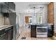 Kitchen view highlighting stainless steel appliances, granite counters, and access to a dining area at 2566 N Emerson St, Denver, CO 80205