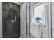 Modern shower with tile surround, glass door, niche for toiletries, and a window for natural light at 2566 N Emerson St, Denver, CO 80205