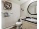 Charming bathroom featuring a decorative seashell wreath, round mirror, and modern vanity at 12391 E Cedar Cir, Aurora, CO 80012