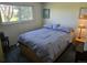 Comfortable bedroom with a queen-size bed, soft blue bedding, and a bright window view at 12391 E Cedar Cir, Aurora, CO 80012