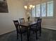 Cozy dining room featuring a wooden table, four chairs, and an elegant chandelier fixture at 12391 E Cedar Cir, Aurora, CO 80012