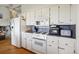 Bright kitchen with white cabinets, tiled backsplash, and white appliances at 12391 E Cedar Cir, Aurora, CO 80012