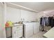 Functional laundry area includes washer, dryer, sink, and storage, making laundry chores more efficient and organized at 12391 E Cedar Cir, Aurora, CO 80012