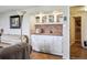 Living room with a built-in bar, white cabinets, and brick backsplash at 12391 E Cedar Cir, Aurora, CO 80012