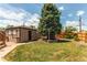 Spacious backyard boasts a lush lawn, shed, and wooden fence for privacy at 753 S Utica St, Denver, CO 80219