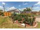 Landscaped backyard with wood fence, lush greenery, mulch bed, and detached garage at 753 S Utica St, Denver, CO 80219