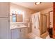 Well-lit bathroom featuring a single vanity, walk-in shower and neutral tile at 753 S Utica St, Denver, CO 80219