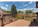 Inviting wooden deck overlooks a lush backyard with mature trees under a sunny, blue sky at 753 S Utica St, Denver, CO 80219