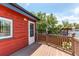 Wooden deck features a door and white trim, showcasing the backyard and greenery at 753 S Utica St, Denver, CO 80219