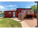Red home exterior shows a wooden deck with stairs and a lush green lawn at 753 S Utica St, Denver, CO 80219
