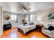 Bright main bedroom with hardwood floors, ceiling fan, and two windows for ample light at 753 S Utica St, Denver, CO 80219