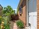 Charming brick home with a white front door, flower garden, and fenced yard for added privacy at 3580 Krameria St, Denver, CO 80207
