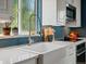 Bright kitchen with a farmhouse sink, stainless steel appliances, white cabinetry, and elegant faucet at 3580 Krameria St, Denver, CO 80207