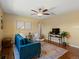 Inviting living room featuring a blue velvet sofa, ceiling fan, modern art, and hardwood floors at 3580 Krameria St, Denver, CO 80207