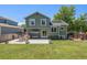 The back exterior of the home with patio, furniture, and lush green lawn at 5102 S Lisbon Way, Centennial, CO 80015