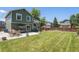 The back exterior of the house shows a large yard with a patio, table, and swing at 5102 S Lisbon Way, Centennial, CO 80015