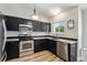 Modern kitchen with sleek black cabinets, stainless steel appliances, and granite countertops at 5102 S Lisbon Way, Centennial, CO 80015