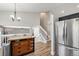 Bright kitchen with stainless steel refrigerator, wooden island, and an adjacent staircase at 5102 S Lisbon Way, Centennial, CO 80015