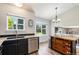 Well-lit kitchen with dark cabinets, a stainless steel dishwasher, and a center island at 5102 S Lisbon Way, Centennial, CO 80015