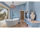 Luxurious bathroom features a soaking tub, walk-in closet, and blue walls at 166 S Rainbow Trl, Evergreen, CO 80439