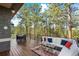 Outdoor deck featuring wood flooring, outdoor seating and dining set amongst a forest backdrop at 166 S Rainbow Trl, Evergreen, CO 80439