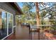 Expansive deck area with outdoor seating and dining options, offering stunning views of the surrounding trees at 166 S Rainbow Trl, Evergreen, CO 80439