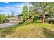 Inviting home exterior showcasing lush greenery, multiple car garage, and a charming entryway at 166 S Rainbow Trl, Evergreen, CO 80439