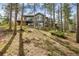 Hillside view of a large home with a deck and many windows, surrounded by tall pine trees at 166 S Rainbow Trl, Evergreen, CO 80439