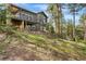 View of a large two-story home with upper and lower decks, nestled into a wooded hillside at 166 S Rainbow Trl, Evergreen, CO 80439