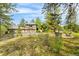 Beautiful exterior showcasing lush landscaping, ample parking, and inviting outdoor seating area at 166 S Rainbow Trl, Evergreen, CO 80439