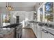 Well-lit gourmet kitchen featuring stainless steel appliances, wine cooler, granite counters, and a view of the trees at 166 S Rainbow Trl, Evergreen, CO 80439