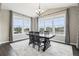 Elegant dining room with large windows, a stylish chandelier, and a dark wood table at 16881 E 110Th Ave, Commerce City, CO 80022