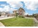 Beautiful two-story home showcasing stone accents, a well-manicured lawn, and vibrant red shutters at 16881 E 110Th Ave, Commerce City, CO 80022